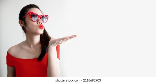 Asian Beautiful Woman Are Wearing Red Eyeglasses And Hold  With Kiss Or Pucker Up Her Lips With Happiness.