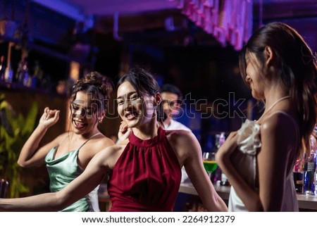 Asian beautiful women having fun, meeting each other in bar restaurant. Attractive young girll friends feeling happy and relax having a party, drinking an alcohol to celebrating event at night club.