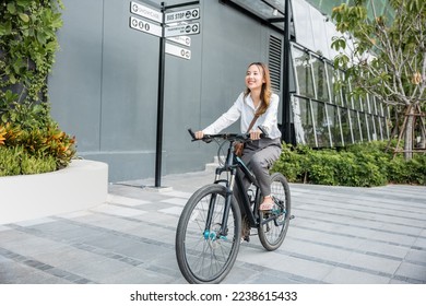 Asian beautiful young businesswoman with helmet riding bicycle go to office work at city street with bicycle in morning, Happy lifestyle woman bike after business work outside building , Eco friendly - Powered by Shutterstock