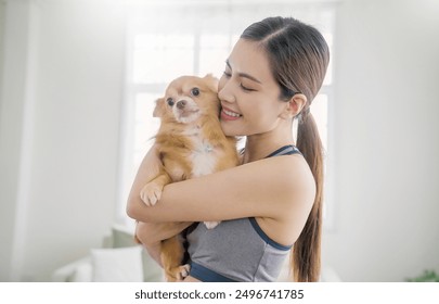 Asian beautiful young lady woman holding dog on sofa living room. Pet dog lover spend leisure time at home. Portrait of cheerful female owner smile on cozy sofa couch playing with best friend dog. - Powered by Shutterstock