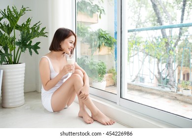 Asian Beautiful Young Woman Drinking Milk At Home