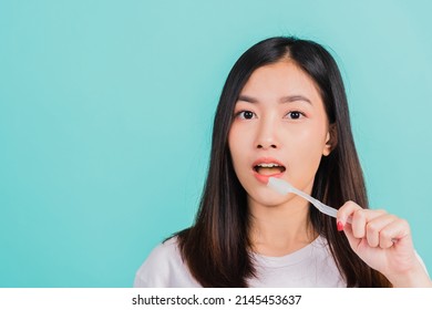 Asian Beautiful Young Woman Teen Brushing Teeth In The Morning, Portrait Of Happy Thai Female Confident Smiling Holding Toothbrush, Studio Shot Isolated On Blue Background, Dental Health Concept