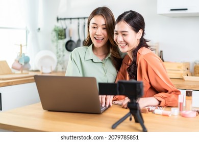 Asian Beauty Blogger Influencer Woman Checking Sale Order On Computer. Attractive Beautiful Business Lesbian Friend Vlogger Sit On Table, Feel Happy After Look At Financial On Laptop Computer In House