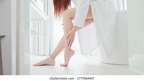 Asian beauty massage leg gently in bathroom
