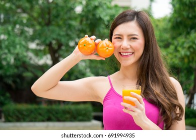 Asian beauty woman eat orange juice for health with smile