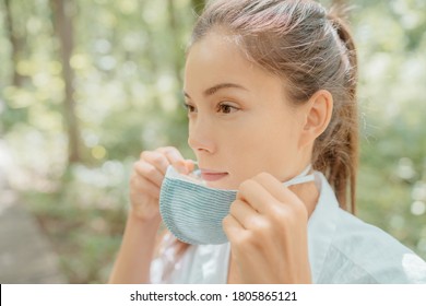 Asian Beauty Woman Putting On Mask On Face. Wearing Corona Virus Prevention Masks For Long Hours Are Creating Irritation, Skin Problems, Acne Pimples.