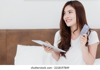 Asian Beauty Woman Use A Credit Card To Make Purchases Using A Tablet Through The Internet With A Happy Smiling Face, Being A New Normal Online Business In The Shopping Experience From Home.