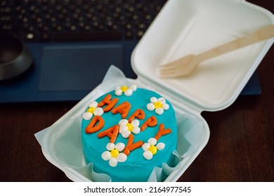 Asian bento box blue cake with daisies, happy day inscription, blurred laptop in the background. Delicious beautiful dessert. Small gift holiday. Korean style cakes box fork one person. A break work. - Shutterstock ID 2164977545