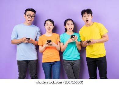 Asian Best Friend Group Using Cell Phone On Purple Background
