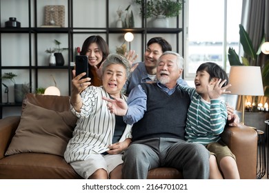 Asian big family look talk to camera and waving hand at home. video calling communicate in online chat - Powered by Shutterstock