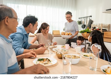 Asian Big Happy Family Having Lunch On Eating Table Together In House. Senior Elder Grandparent, Young Couple And Little Kid Daughters Feel Happy, Enjoy Eat Food At Home. Activity Relationship Concept