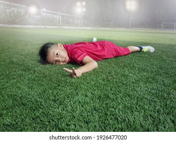 Asian Boy 6 Years Old Hands Up To Fight With Resting On Artificial Grass In Soccer Field After Practice Skill Football