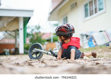 Asian Boy About 2 Years Is Riding Baby Balance Bike And Fall, Get Up On His Own, Playing And Learning Concept