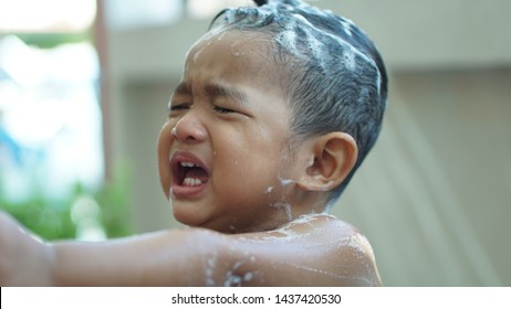 
Asian boy aged 18 months, showering and washing hair, weeping water, pouring water into the eyes, burning eyes, using violence against children, forced concept.