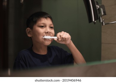 Asian Boy Brushing Teeth In The Bathroom