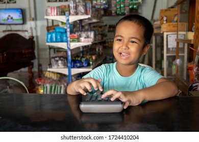 Asian Boy With Calculator.Boy Playing Merchant Role Play In Grocery.