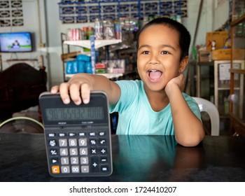 Asian Boy With Calculator.Boy Playing Merchant Role Play In Grocery.