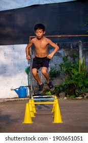 Asian Boy Or Child 11 Years Old  Steping Over Yellow Mini Hurdles In Pracktic Skill Football From Home