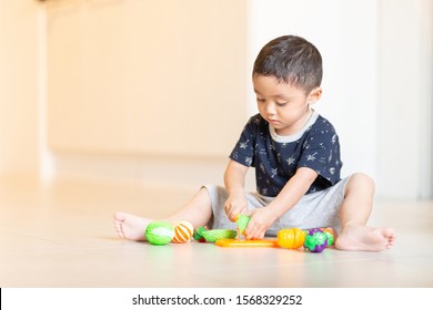 Asian Boy Child Having Fun Playing Alone With Cooking Toys, Soft Focus.