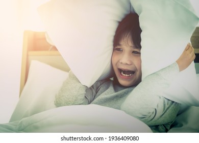 Asian Boy Covering Ear With Pillow After Waking Up From Nightmare Sleepless Insomnia Night On Bed In The Morning.