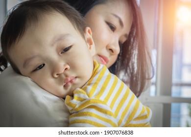 An Asian Boy Was Crying With Sad Face Expression, Being Carry And Hug By His Mother To Calm Down. The Child (toddler, Kid) Cries Because Of Discomfort From Sick Fever.