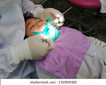 Asian Boy Crying While Dentist Checking Decay Problem Cause By Careless Brushing Teeth.Decay And Toothache In Children Concept.