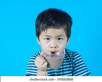 Asian Boy Drinking Chocolate Milk On Blue Background,