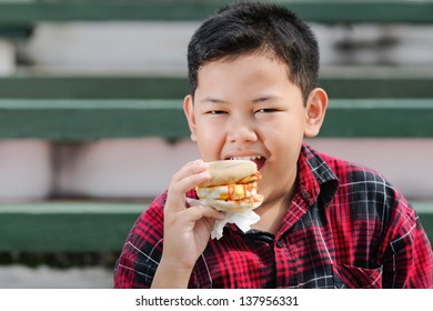 Asian Boy Eating Muffin Sandwich