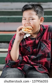 Asian Boy Eating Muffin Sandwich