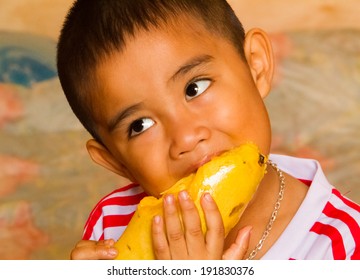 Asian Boy Eating Yellow Mango.