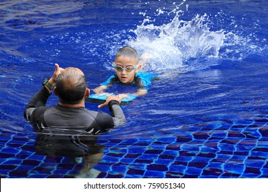 Asian Boy Gets Swimming Lessons From Coach