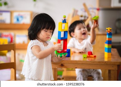 Asian boy and girl playing with colorful plastic blocks. Learning and imagination of young children. Hand muscle development. Toy sharing. Baby age 1 years and 2 years old. - Shutterstock ID 1595238376
