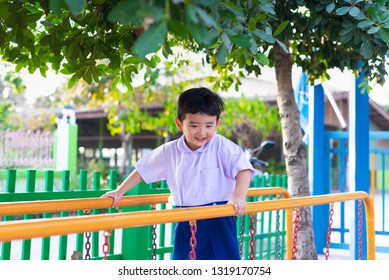 Asian Boy Hang The Monkey Bar Or Balance Bar For Balance At Outdoor Playground In Summer.