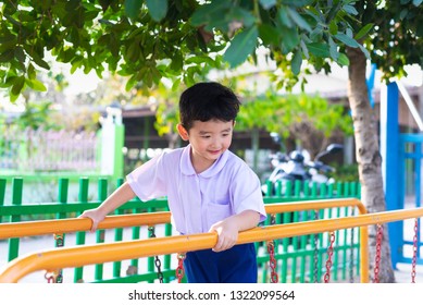 Asian Boy Hang The Monkey Bar Or Balance Bar For Balance At Outdoor Playground In Summer.