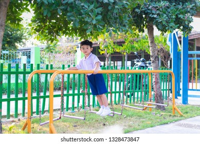 Asian Boy Hang The Monkey Bar Or Balance Bar For Balance At Outdoor Playground In Summer.