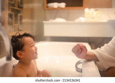 Asian Boy Happily Playing With Mom And Taking A Bath In The Tub.