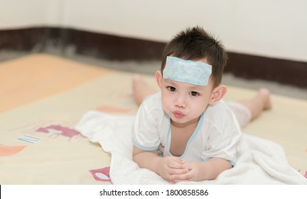 Asian boy having fever . The kid attach cooling gel pad on his forehead for relief fever - Shutterstock ID 1800858586