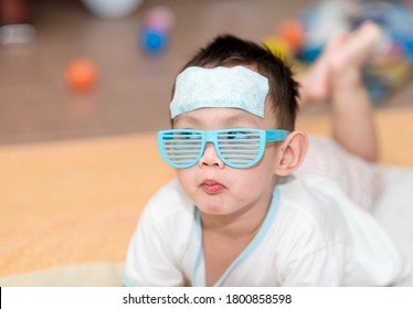 Asian boy having fever . The kid attach cooling gel pad on his forehead for relief fever - Shutterstock ID 1800858598