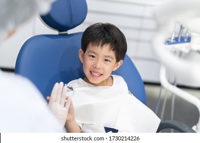 An Asian boy having teeth examined at dentists: Healthy lifestyle, healthcare, and medicine concept.