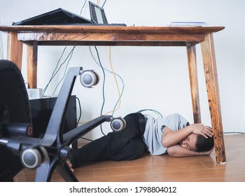 Asian Boy Hiding Under Table Because Of Earthquake.