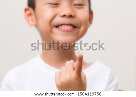 Asian boy hold with a contact lens