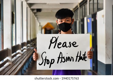 Asian boy holds a paper with English words ‘Please Stop Asian Hate’, concept for calling the international community to stop the hatred of the Asian people that have caused spreading of the covid-19.