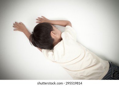 Asian Boy Kid Lying Down On White Floor Like Accident Or Fainting Top View