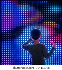 Asian Boy Playing With Colorful Led Light Interaction Wall