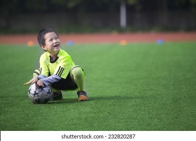 Asian Boy Playing Football With Happy