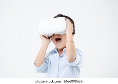 Asian Boy Playing Game In Vr Glasses. Child Touch Something Using Modern Virtual Reality Glasses