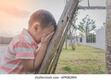 Asian Boy Playing Hide And Seek In Park