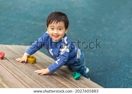 Asian boy is playing in playground with happy face in summer. Copy space for text