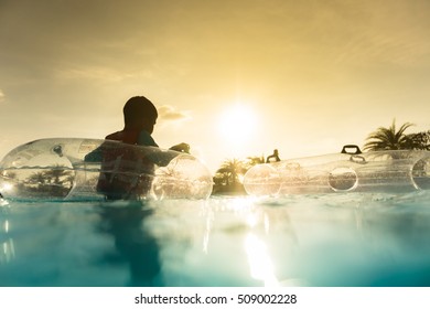 Asian Boy Playing In Water Park, Sunset Scene