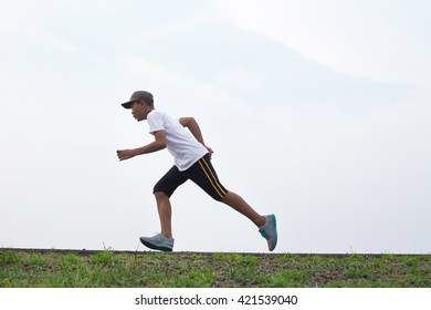 Asian Boy Running On The Scenic Road.